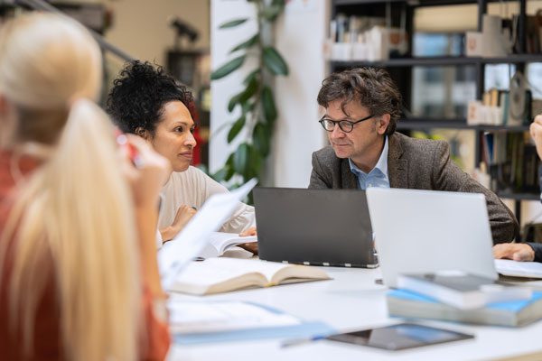 Photo of school leaders gathered around a table in discussion