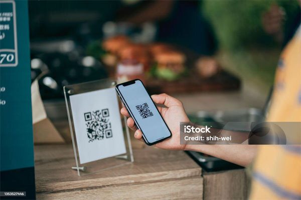 Image of a person scanning a QR code with their phone.