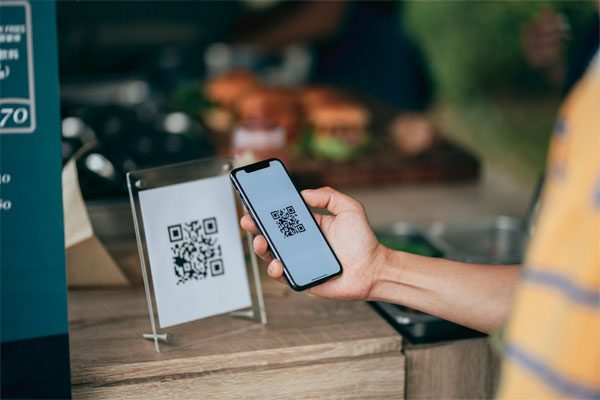 Image of a person scanning a QR code with their phone.