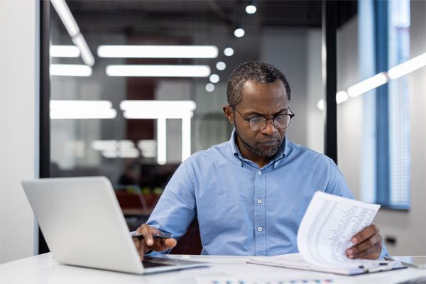 Image of a person on a laptop reviewing a document